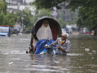 A rickshaw puller is going through a flooded street after heavy monsoon rainfall in Dhaka, Bangladesh, on July 12, 2024. (