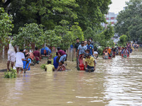 People are moving on rickshaws along a flooded street after a downpour in Dhaka, Bangladesh, on July 12, 2024. (