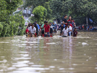 People are moving on rickshaws along a flooded street after a downpour in Dhaka, Bangladesh, on July 12, 2024. (