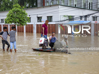 People are moving on rickshaws along a flooded street after a downpour in Dhaka, Bangladesh, on July 12, 2024. (