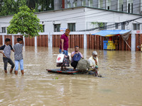 People are moving on rickshaws along a flooded street after a downpour in Dhaka, Bangladesh, on July 12, 2024. (