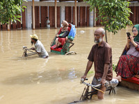 People are moving on rickshaws along a flooded street after a downpour in Dhaka, Bangladesh, on July 12, 2024. (