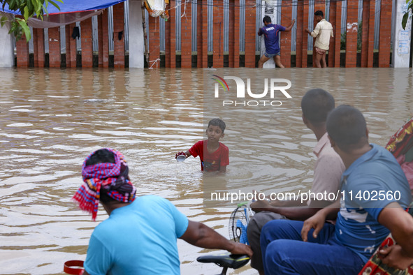 People are moving on rickshaws along a flooded street after a downpour in Dhaka, Bangladesh, on July 12, 2024. 