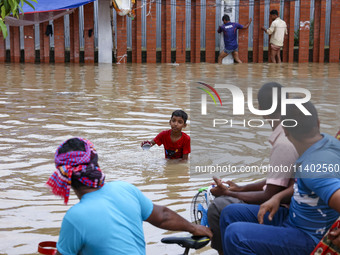 People are moving on rickshaws along a flooded street after a downpour in Dhaka, Bangladesh, on July 12, 2024. (