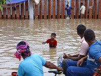 People are moving on rickshaws along a flooded street after a downpour in Dhaka, Bangladesh, on July 12, 2024. (