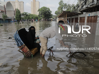 A rickshaw puller is wading through a waterlogged street after a heavy downpour in Dhaka, Bangladesh, on July 12, 2024. (