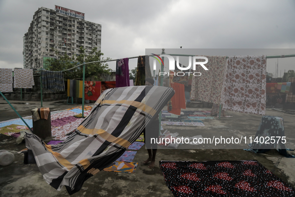 Street vendors are drying their goods on the roof of a market after it is waterlogged following a heavy downpour in Dhaka, Bangladesh, on Ju...