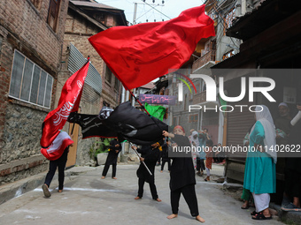 Kashmiri Shiite Muslim children are waving religious flags during a Muharram procession on the fifth day of Ashura, in Srinagar, Jammu and K...