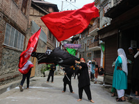 Kashmiri Shiite Muslim children are waving religious flags during a Muharram procession on the fifth day of Ashura, in Srinagar, Jammu and K...