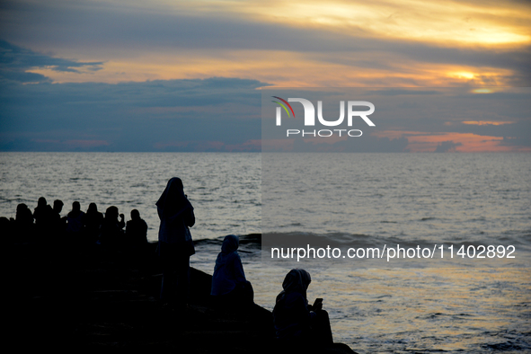 People are enjoying the sunset at Padang Beach in West Sumatra, Indonesia, on July 12, 2024. 