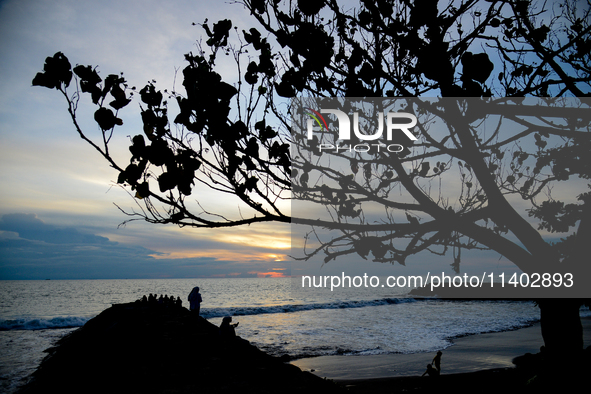 People are enjoying the sunset at Padang Beach in West Sumatra, Indonesia, on July 12, 2024. 