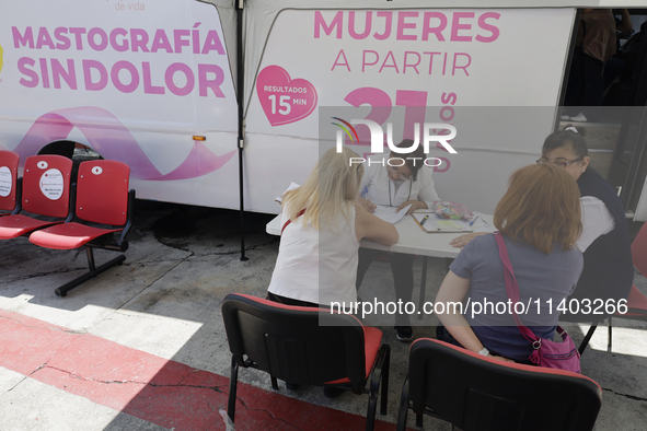 Medical staff are attending to users outside a mobile unit with two clinics and two mastographs in Mexico City, Mexico, as part of the free...