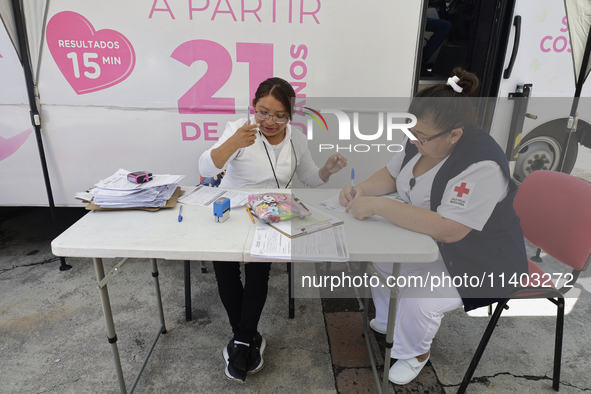 Medical staff are waiting for users outside a mobile unit with two clinics and two mastographs in Mexico City, Mexico, as part of the free m...