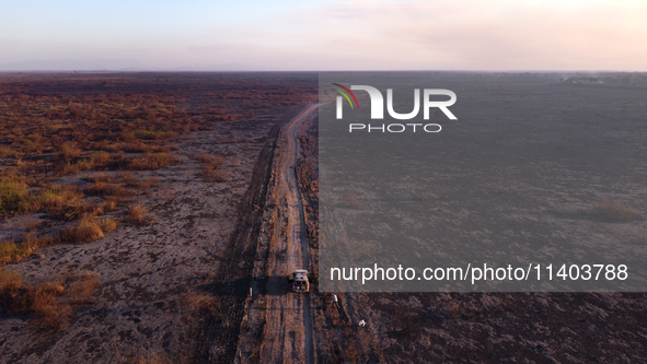 A National Security Force vehicle is traveling along a road bordered by areas scorched by forest fires that have been devastating the southe...