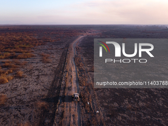 A National Security Force vehicle is traveling along a road bordered by areas scorched by forest fires that have been devastating the southe...