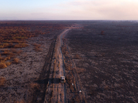 A National Security Force vehicle is traveling along a road bordered by areas scorched by forest fires that have been devastating the southe...