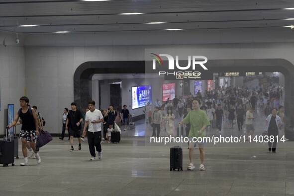 Passengers are passing through the gate at the exit of the East high-speed railway station in Huai'an city, East China's Jiangsu province, o...