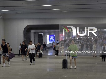 Passengers are passing through the gate at the exit of the East high-speed railway station in Huai'an city, East China's Jiangsu province, o...