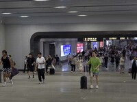 Passengers are passing through the gate at the exit of the East high-speed railway station in Huai'an city, East China's Jiangsu province, o...