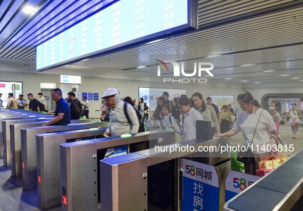 Passengers are passing through the gate at the exit of the East high-speed railway station in Huai'an city, East China's Jiangsu province, o...