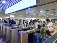 Passengers are passing through the gate at the exit of the East high-speed railway station in Huai'an city, East China's Jiangsu province, o...