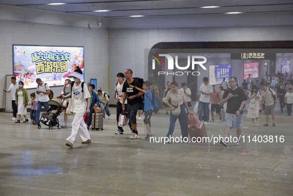 Passengers are passing through the gate at the exit of the East high-speed railway station in Huai'an city, East China's Jiangsu province, o...