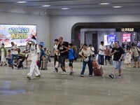 Passengers are passing through the gate at the exit of the East high-speed railway station in Huai'an city, East China's Jiangsu province, o...