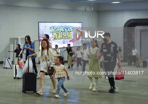 Passengers are passing through the gate at the exit of the East high-speed railway station in Huai'an city, East China's Jiangsu province, o...