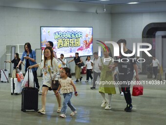 Passengers are passing through the gate at the exit of the East high-speed railway station in Huai'an city, East China's Jiangsu province, o...