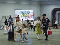 Passengers are passing through the gate at the exit of the East high-speed railway station in Huai'an city, East China's Jiangsu province, o...