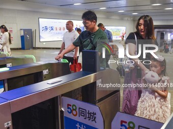 Passengers are passing through the gate at the exit of the East high-speed railway station in Huai'an city, East China's Jiangsu province, o...