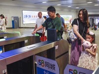 Passengers are passing through the gate at the exit of the East high-speed railway station in Huai'an city, East China's Jiangsu province, o...