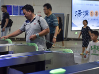 Passengers are passing through the gate at the exit of the East high-speed railway station in Huai'an city, East China's Jiangsu province, o...