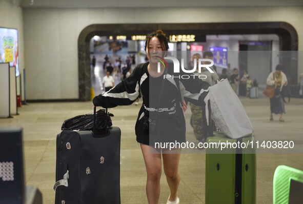 Passengers are passing through the gate at the exit of the East high-speed railway station in Huai'an city, East China's Jiangsu province, o...