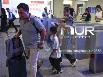 Passengers are passing through the gate at the exit of the East high-speed railway station in Huai'an city, East China's Jiangsu province, o...