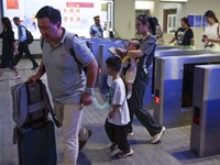 Passengers are passing through the gate at the exit of the East high-speed railway station in Huai'an city, East China's Jiangsu province, o...