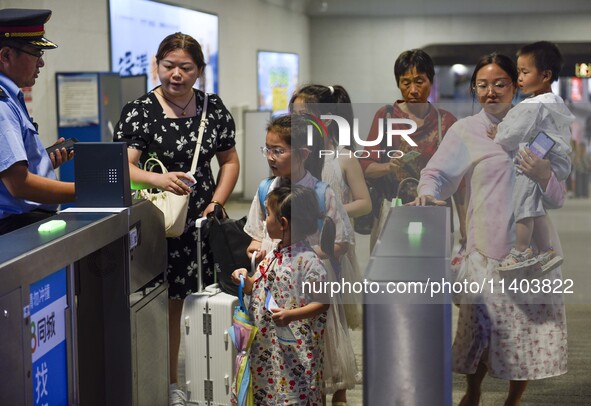 Passengers are passing through the gate at the exit of the East high-speed railway station in Huai'an city, East China's Jiangsu province, o...