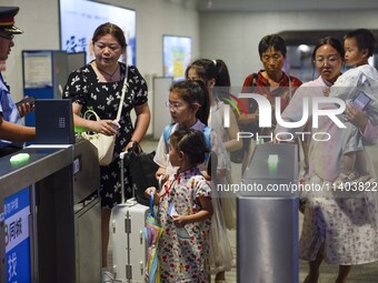 Passengers are passing through the gate at the exit of the East high-speed railway station in Huai'an city, East China's Jiangsu province, o...