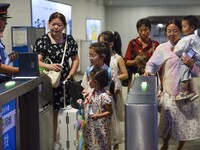 Passengers are passing through the gate at the exit of the East high-speed railway station in Huai'an city, East China's Jiangsu province, o...