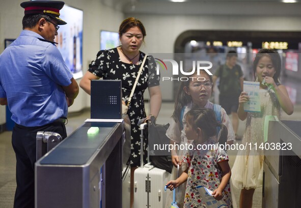 Passengers are passing through the gate at the exit of the East high-speed railway station in Huai'an city, East China's Jiangsu province, o...