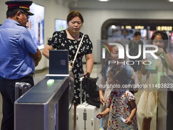 Passengers are passing through the gate at the exit of the East high-speed railway station in Huai'an city, East China's Jiangsu province, o...