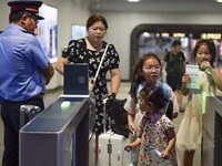 Passengers are passing through the gate at the exit of the East high-speed railway station in Huai'an city, East China's Jiangsu province, o...