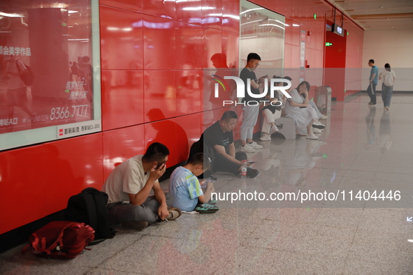 Citizens are cooling off at a subway station in Xi'an, China, on July 12, 2024. 