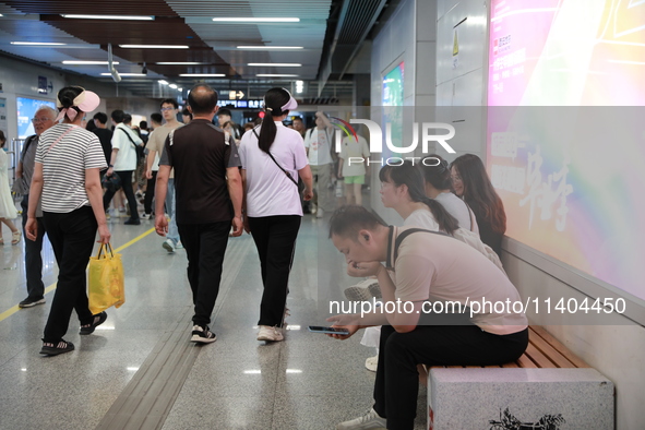 Citizens are cooling off at a subway station in Xi'an, China, on July 12, 2024. 