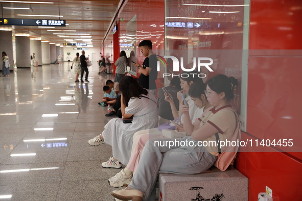 Citizens are cooling off at a subway station in Xi'an, China, on July 12, 2024. 