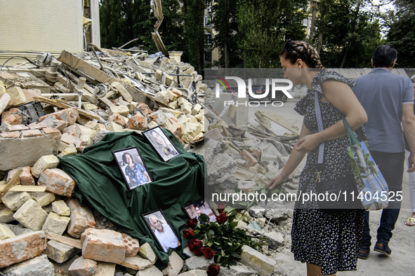 People are bringing flowers to the portraits of doctors and patients who died in Okhmatdyt Children's Hospital that was recently hit by a Ru...