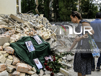 People are bringing flowers to the portraits of doctors and patients who died in Okhmatdyt Children's Hospital that was recently hit by a Ru...