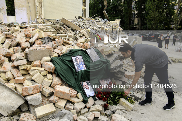 People are bringing flowers to the portraits of doctors and patients who died in Okhmatdyt Children's Hospital that was recently hit by a Ru...