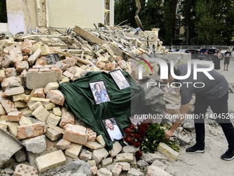 People are bringing flowers to the portraits of doctors and patients who died in Okhmatdyt Children's Hospital that was recently hit by a Ru...