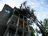 A fallen tree is leaning on a residential building in the Mokotow district after an overnight storm is hitting Warsaw, Poland, on July 13, 2...